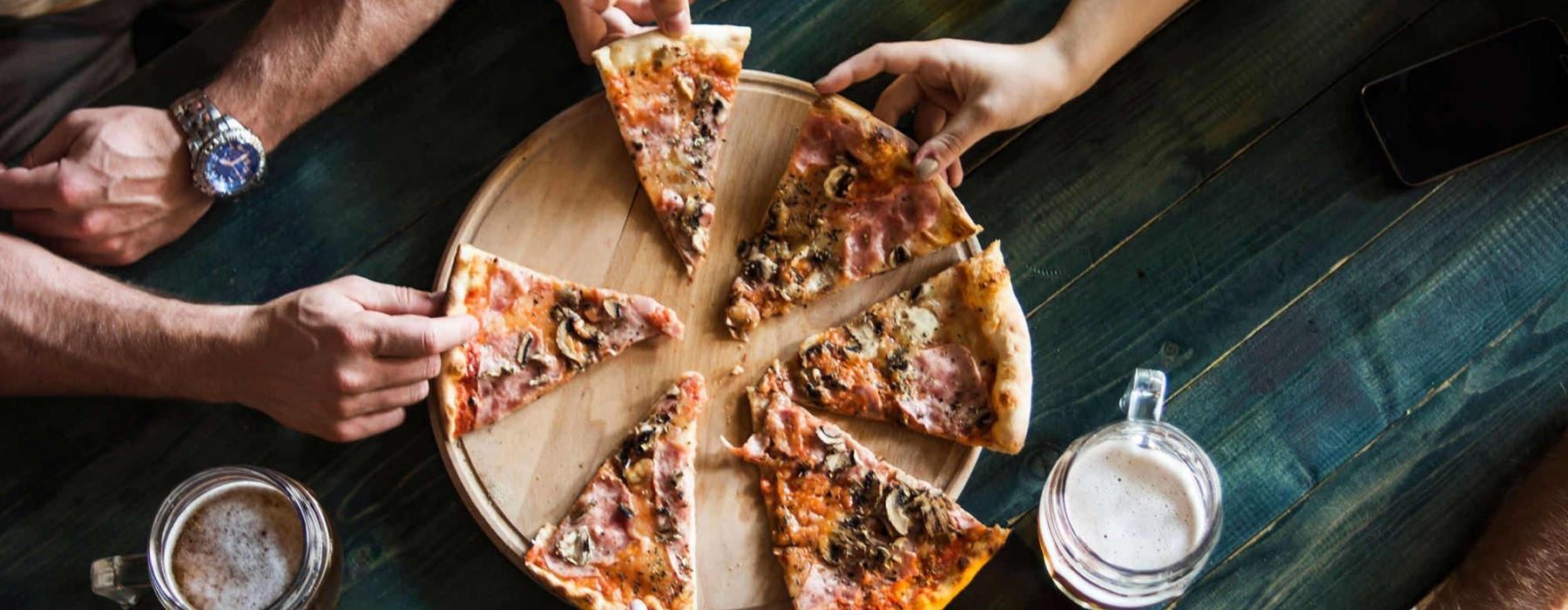 a group of people eating pizza