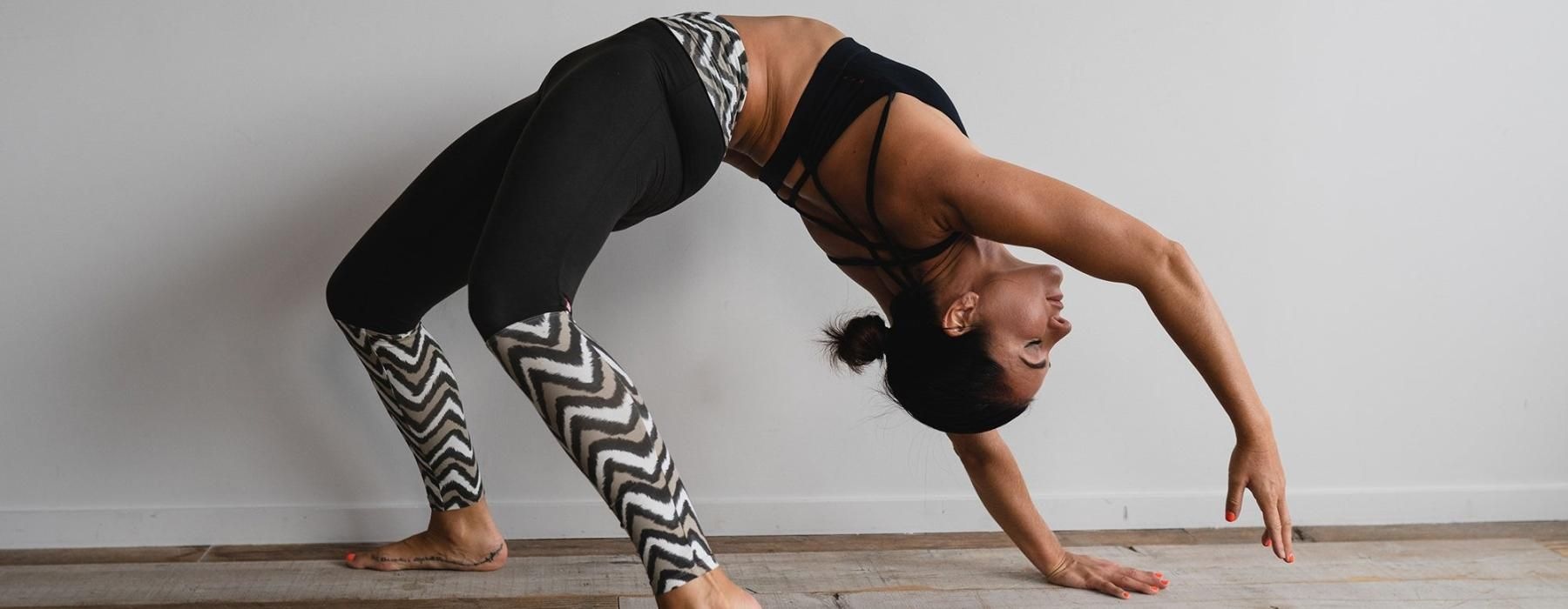 woman bending over backwards in an exercise studio