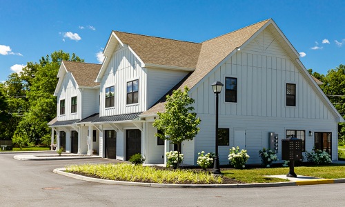 large white building with grass and a street in front